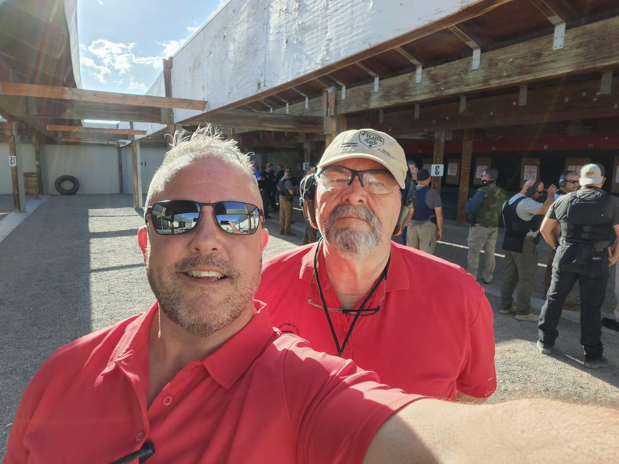 Guy Beveridge and Randy Harris on the range line during a class, officers running an evolution behind them.