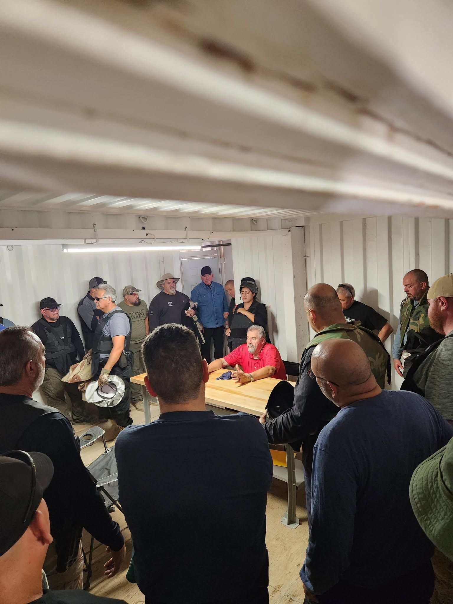 An instructor briefing officers inside the shoot house before a force-on-force scenario.